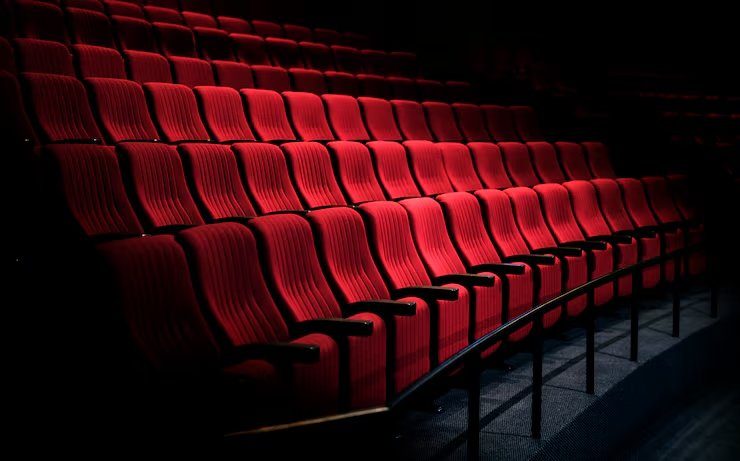 Rangées de fauteuils rouges dans une salle de théâtre